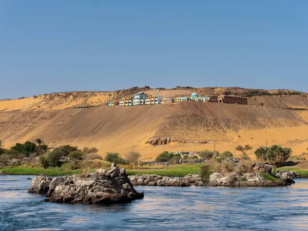 stock image A row of colorful buildings and houses of the ancient Nubian people on the hill along the Nile in Aswan, Egypt.