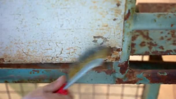 人工用金属笔刷去除旧的褪色的白色和蓝色油漆 去除金属表面上的腐蚀 修补工地上的工程 处理钢铁上的严重腐蚀 — 图库视频影像