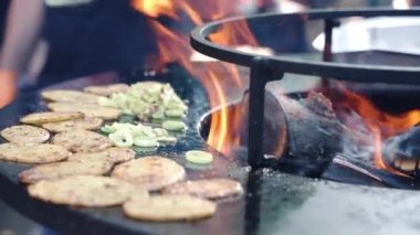 Baharatlı patates ve soğan ızgarası ızgara ızgara ızgara ızgara taze sebzeler barbekü piknik partisi için kızartılıyor. BBC içicisinde yangın alevleri, ateşte kızartılmış sebze kavramı. Yüksek kalite 4k