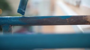 Aşınmış demir çerçevenin parlak mavi renkte, yumuşak fırçayla kaplanmış paslı yüzey, tamir işleri, demir inşaat yenileme. Yüksek kalite 4k görüntü