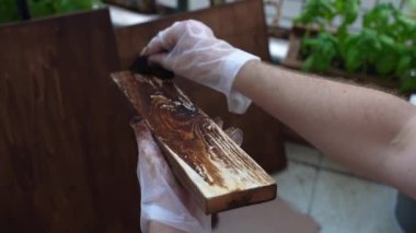 Ahşap kaplamalarla çalışan, tahta yüzeyi restore eden, işçilerin boyadığı ve kahverengi renkte ahşap cilalayan, endüstriyel sünger kullanan, tahtaları tahribattan korumak için birleştiren tamirci. Yüksek