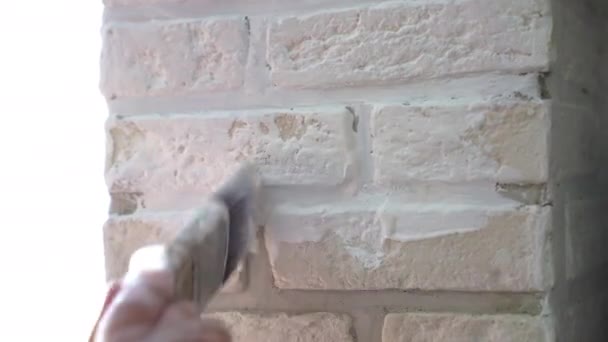小さな石のタイルで飾られたホームインテリアコラム 白い色の塗料で石の表面をコーティング手袋の工業労働者 壁のテクスチャの復元されたアパートのデザイン ホーム改善コンセプト — ストック動画