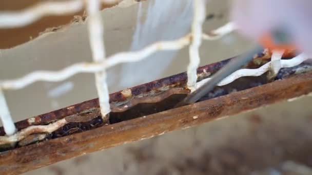 金属表面上的锈蚀残留物 用剥皮机去除钢门上的锈蚀的过程 建筑工地上的繁重工作 承包商在手套中擦拭金属表面 钢维修 — 图库视频影像