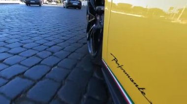 ROME, İtalya - 7 Kasım 2022: Özel sarı Lamborghini 'nin hızlı kaldırım taşı sürüşü, hareket halindeki spor araba tekerleği ve ortasında logo olan lastiğin alttaki görüntüsü, premium sınıf arabaların yarışması