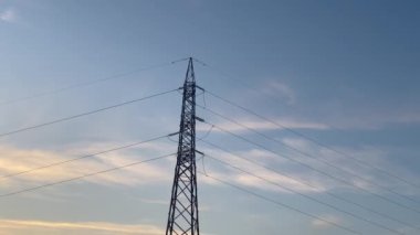 Günbatımında yüksek voltajlı elektrik hatları, iletim ve dağıtım için metal santralleri, Avrupa 'daki enerji krizi, elektrik santralleri ve