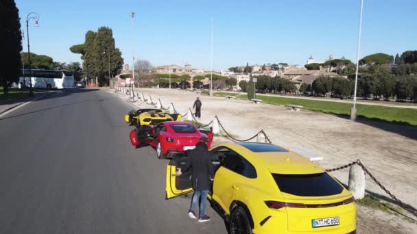 ローマ イタリア 2022年11月7日 ドライバは ローマの通りに沿ってレースにスポーツカーに入る 排他的な赤フェラーリと黄色のランボルギーニは フォリImperali 航空路の側に駐車 — ストック動画