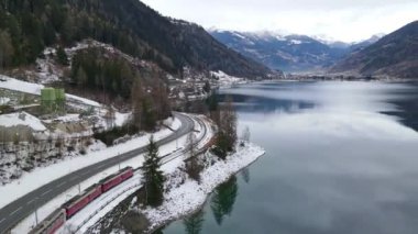 İsviçre 'nin şaşırtıcı kış doğası, yüksek kayalar ve uçurumlar bulutlu hava günlerinde karla kaplı, İsviçre dağlarının ortasında koyu yeşil yarı donmuş göl, geçen ünlü İsviçre' nin havadan çekilmiş görüntüsü.