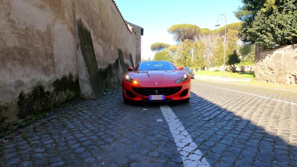 ローマ イタリア 2022年11月7日 右方向のヘッドライトが点滅し 石畳の道路の側面に排他的な赤いフェラーリを停止し 高級赤スポーツのフロントビューフェラーリは 上の運転 — ストック動画