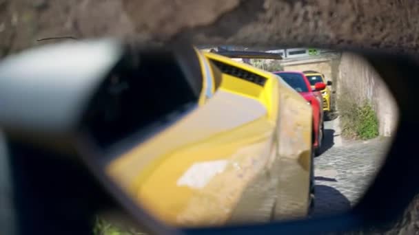 ローマ イタリア 2022年11月7日 道路上の排他的なイタリアの赤フェラーリと黄色のランボルギーニ 黄色のランボルギーニ プレミアムクラスの車の性能のサイドビューミラーでスポーツカーの反射 — ストック動画
