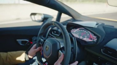 View from inside of driving car on highway, man steering wheel of super sports car with powerful motor engine, exclusive interior design of the car, driving on highway concept. High quality 4k footage