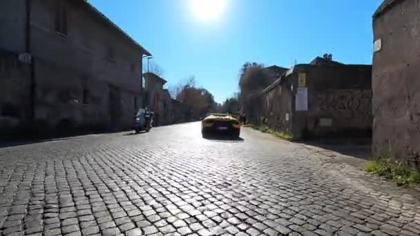 ローマ イタリア 2022年11月7日 古代ローマの田舎の通りを横切る黄色のランボルギーニのカブリオレレース 石畳の道での走行性能を示す強力なエンジンを備えたスーパーカー — ストック動画