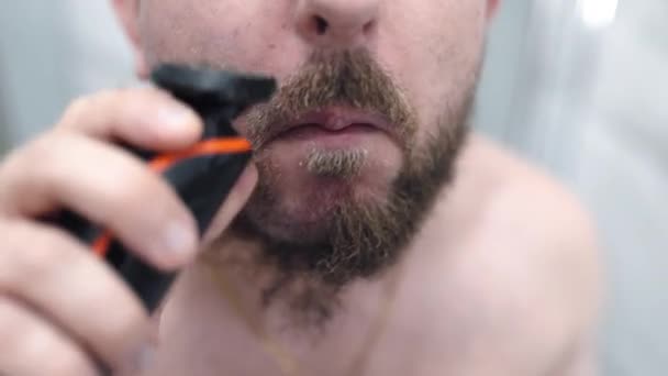 Handsome Man Shaving His Beard Electric Trimmer Front Mirror Bathroom — Stockvideo