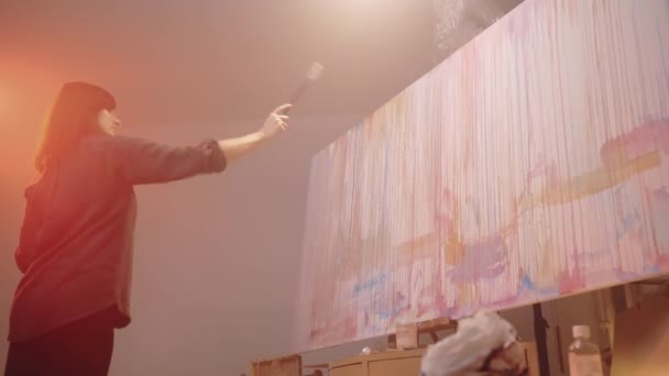 現代美術における革新的な油絵の方法は 才能のある女性アーティストは 抽象的な効果を作成するために色のドロップでキャンバス画像を噴霧 インスピレーションを受けた画家は展覧会のためのアートワーク — ストック動画