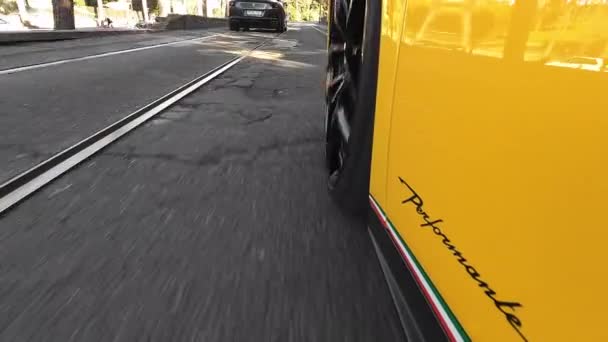 ローマ イタリア 2022年11月7日 路面電車の線路を通って古代ローマの通りを横断する排他的な黄色のランボルギーニの運転 道路上でレース中にランボルギーニホイールを回転 — ストック動画