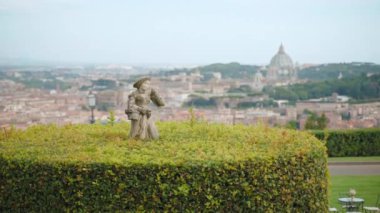 Famous Vatican city panoramic view from the ancient Villa terrace, architectural Vatican Dome visible among the Roman buildings against sky background, stone sculpture overgrown with beautifully