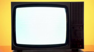 Old vintage TV on yellow background, blinking screen and horizontal stripes on television display, bad satellite signal on antique TV, broken television with noise and bars interference on monitor