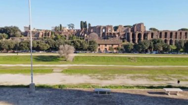 ROME, ITALY - NOVEMBER 7, 2022: Group of young millionaires talking against Fori Imperiali background, exclusive sports cars parked on the side road in the downtown of ancient Rome, yellow Lamborghini