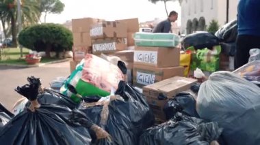 ROME, ITALY - 10 Mart 2022: Kapalı siyah paketler ve karton kutularla yapıştırılmış kağıt çarşaf ve yazılı gıda ve hijyen ürünleri, Roma 'daki Aziz Sophia Kilisesi Derneği insani yardım hazırlığı