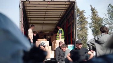 ROME, ITALY - MARCH 10, 2022: Volunteers association of St. Sophia Church in Rome loading truck with humanitarian aid for Ukrainian refugees, men loading cartoon boxes and packages with basic