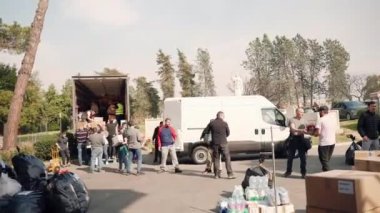 ROMA, İtalya - 10 Mart 2022: Roma 'da gönüllülerin Ukraynalı mültecilere insani yardım kamyonları yüklemesi, insanların karton kutuları ve yiyecek, giyecek gibi temel ihtiyaçlarla dolu paketleri yüklemesi