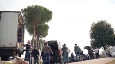 ROME, ITALY - MARCH 10, 2022: People loading truck and van with boxes and packages of necessary humanitarian aid for Ukrainian nation, volunteers association of St. Sophia Church in Rome organised