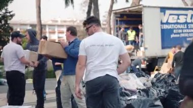 ROMA, İtalya - 10 Mart 2022: İnsanlar Roma 'daki St. Sophia Kilisesi' nin ön bahçesine Ukraynalı evsiz insanlar ve hayvanlar için insani yardım dolu kutuları ve paketleri yüklüyorlar. Yüksek