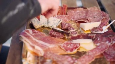 Selection of high quality appetizers on tray in local restaurant of Italian cuisine, dried salami slices, parmigiano cheese, gorgonzola, brezaola and prosciutto slices for tasting, variety of meat and