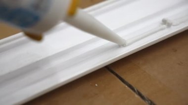 Beyaz süpürgelik yüzeyine endüstriyel tüple yapıştırıcı sürüyorum. İnşaat alanına dolgu malzemesi yerleştirmek için beyaz dolgu malzemesi. Ev yapımı için yapıştırıcı kullanıyorum. Yüksek kalite 4k görüntü