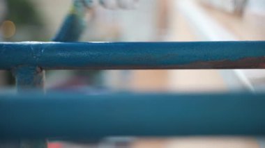 Process of renovation steel surface with chemical solution to protect from corrosion, worker in gloves coating metal frame surface with blue colour using paintbrush, transformation of eroded balcony