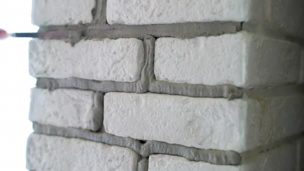 装飾石の壁に接合部をグラウト人 特殊工業用グラウンドへらでセメントをライニング労働者 装飾石タイルの設置と表面の質感の復元 — ストック動画