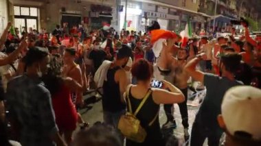 ROME, ITALY - JULY 11, 2021: Italian happy fans celebrating victory of football match euro 2020 on the streets of Rome, furious people waving national flags, jumping, screaming, burning red smoking
