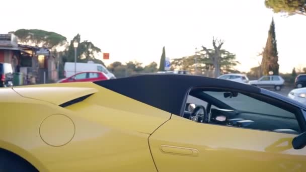 ローマ イタリア 2022年11月7日 ローマの路上で排他的な黄色のランボルギーニと赤フェラーリのスポーツカーの外観の詳細 ロゴの碑文を持つ威信のスポーツカー 強力なスーパーカー — ストック動画