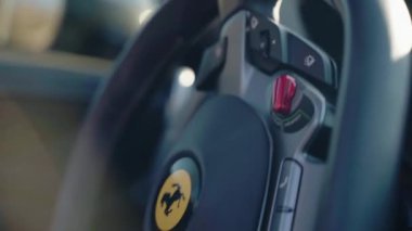 ROME, ITALY - NOVEMBER 7, 2022: Ferrari Portofino coupe 'un özel direksiyon simidi, lüks spor arabanın yüksek kaliteli iç tasarımı, kırmızı direksiyonun çok işlevli düğmeleri