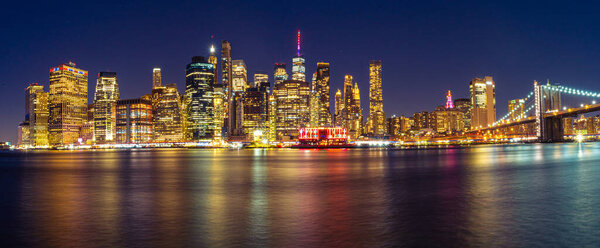 The Manhattan Skyline during Night view with Brooklyn Bridge