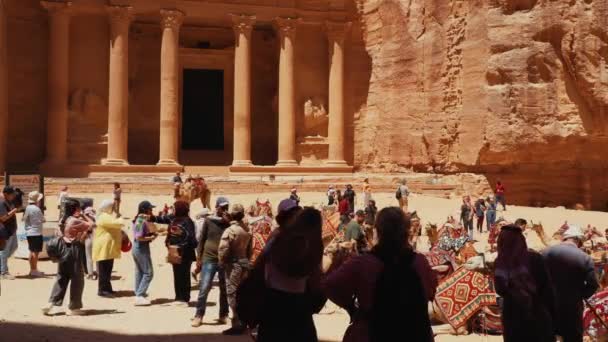 観光客は ヨルダンのペトラの古代都市で王室の墓の構造を観光しています Loculiとして知られています ペトラはユネスコ世界遺産に指定されました — ストック動画