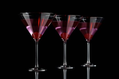 Kirazlı martini bardağında üç kırmızı kokteyl.
