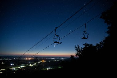 Kazakistan 'ın Almatı' ndaki Shymbulak kayak merkezinde yıldızlı gece gökyüzü olan dağdaki teleferik istasyonu. Yüksek kalite fotoğraf