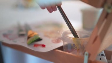 Close-up Shot of Female Artists Hand, Holding Paint Brush and Drawing Oil Painting. Colorful, Emotional Oil Painting. Contemporary Painter Creating Modern Abstract Pieces of Fine Art, amazing shot