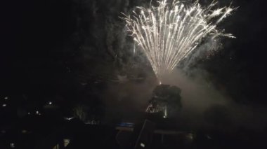 Fireworks in the City Sky. Aerial Drone Scene. City Night Lights. The Camera Rotates in a Semicircle and it is seen how the fireworks explode. Amazing work