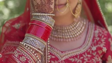 Portrait of a happy Indian bride covering her face with her hand, Hindi on her hand. Very nice girl