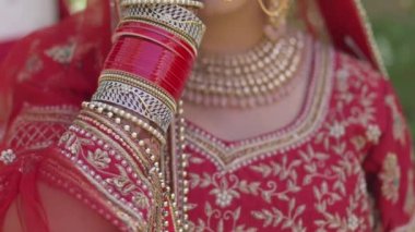 Portrait of a happy Indian bride covering her face with her hand, Hindi on her hand. Very nice girl