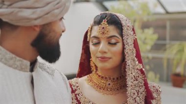 Groom tying cultural sacred thread on brides hand at a traditional Indian wedding. Indian wedding ritual. Shot of a beautiful Indian Bride entering in her wedding