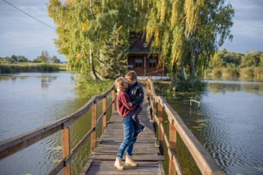 Anne ve mutlu oğul birbirlerini selamlıyor, gururla sarılıyorlar. Anne ve sevimli küçük çocuk dışarıda birlikte oynuyorlar.