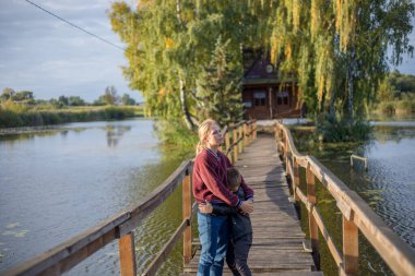 Üzgün genç bir anne, ağlayan küçük oğluna teselli verici bir sarılma verir. Yakışıklı çocuk üzgün görünüyor ve küçük çocuk annesiyle kalmak zorunda çünkü annesi ya da babası boşandı. Tatlı çocuk yorgun görünüyor.