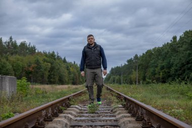 Demiryolunda sıcak bir ışıkla yürüyen bir adam. Demiryolundaki gezgin..