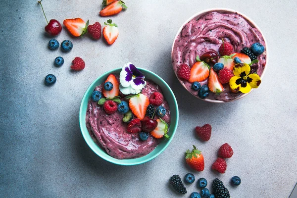 两个夏天 在灰色的混凝土背景下 用草莓和蓝莓做了两个夏天的果冻碗 早餐碗 有水果和麦片 健康食品 — 图库照片