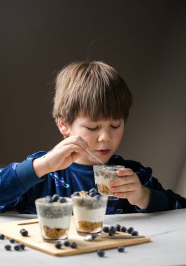 Parfe yiyen çocuk. Çocuk organik yiyecekler yiyor. Vitaminli sağlıklı sebzeler. Gerçek çocuk beslenme konsepti.