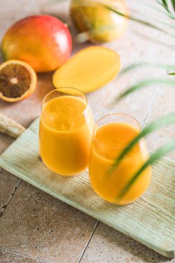 İki mango lassi ya da bardakta kesar süt. Hint sağIıklı ve mangolu soğuk bir içecek. Taze Lassi yoğurttan, sudan, baharatlardan, meyvelerden ve buzdan yapılır..