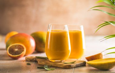 İki mango lassi ya da bardakta kesar süt. Hint sağIıklı ve mangolu soğuk bir içecek. Taze Lassi yoğurttan, sudan, baharatlardan, meyvelerden ve buzdan yapılır..