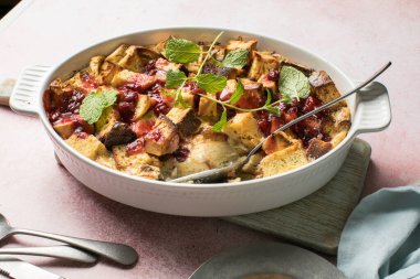 Pembe arka planda reçelli ev yapımı ekmek pudingi. Seçici odak, boşluğu kopyala